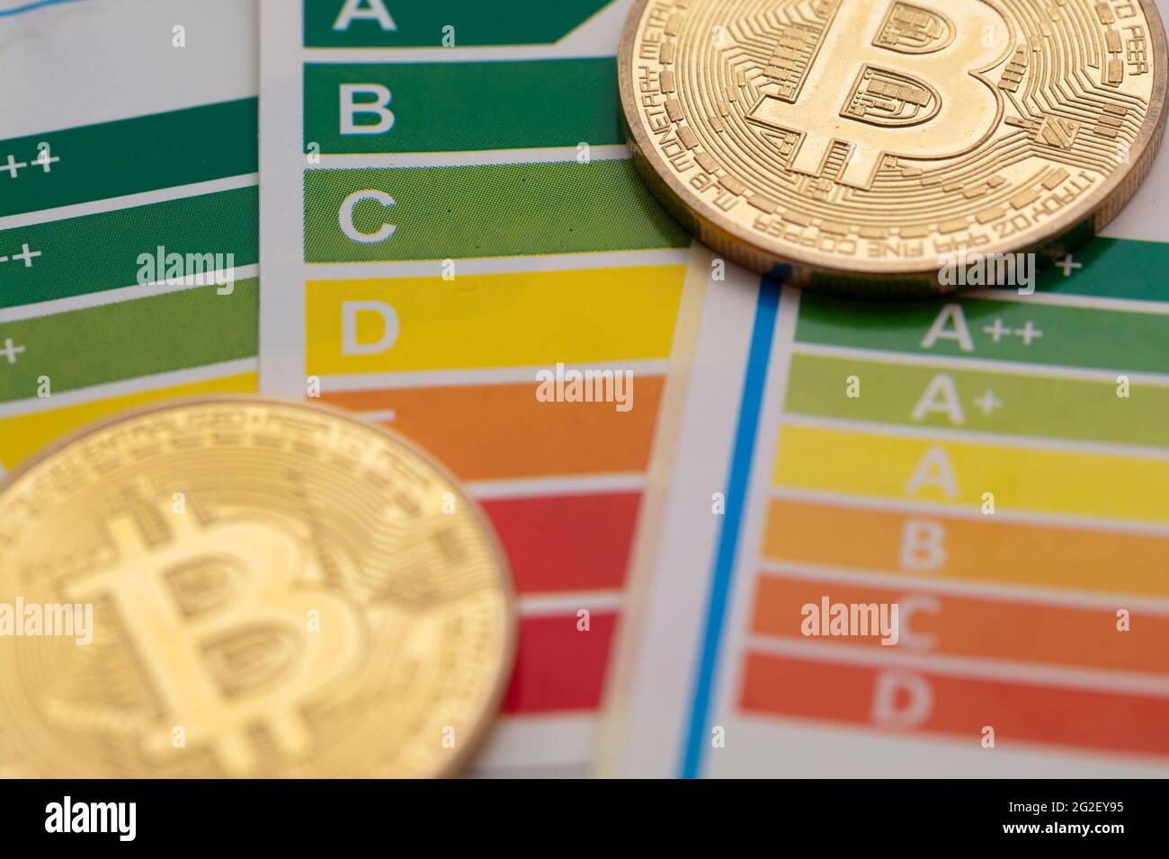 Bitcoin Kryptowährung Goldmünze mit einer Energieeffizienz-Rating-Tabelle Stockfoto