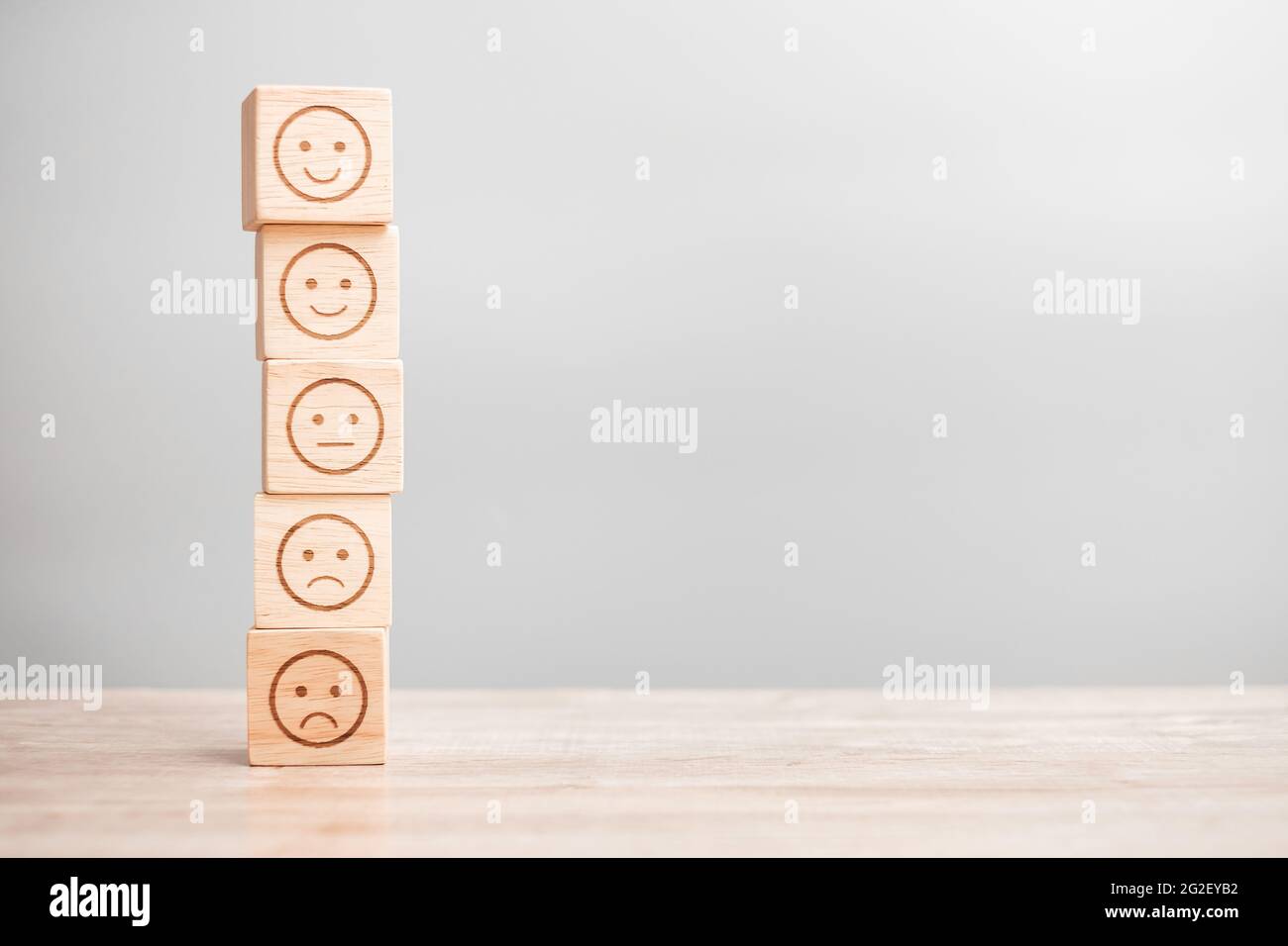 Emotionsgesicht-Symbol auf Holzblöcken. Service Rating, Ranking, Customer Review, Zufriedenheit, Bewertung und Feedback-Konzept Stockfoto