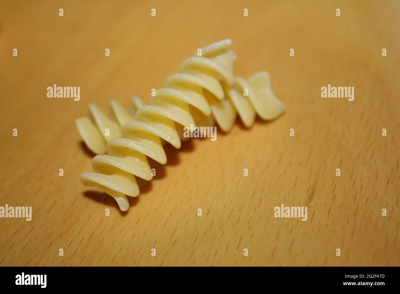 Ungekochte Fusilli italienische Pasta isoliert auf Holz Hintergrund. Stockfoto