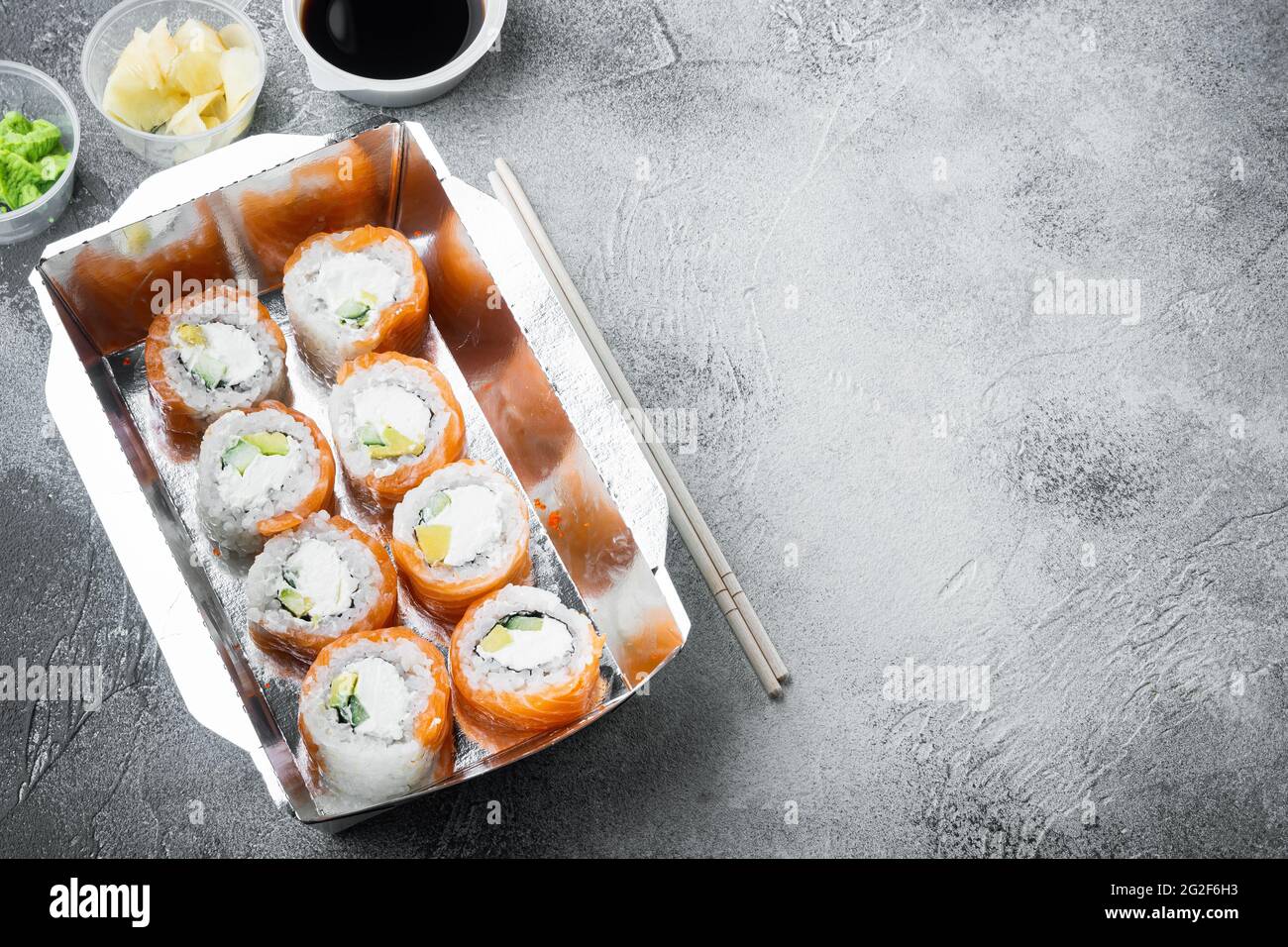 Japanisches Speisekonzept. Catering, verschiedene Arten von Sushi philadelphia Brötchen und gebackene Garnelen Rollen Set, auf grauem Stein Hintergrund , mit Copyspace und sp Stockfoto