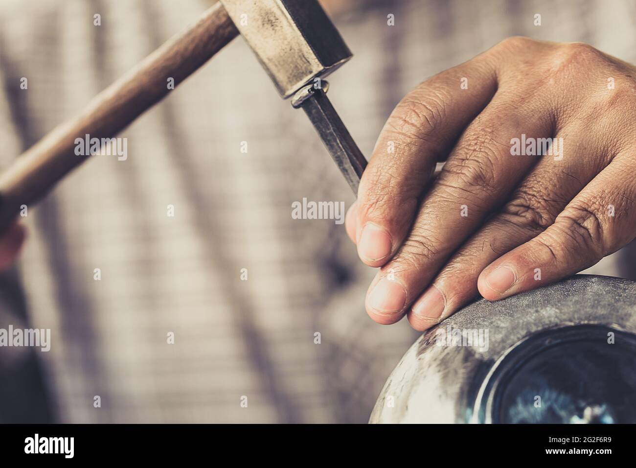 Nahaufnahme professionelle männliche Handarbeit Arbeitshammer auf der silbernen Zinn Schüssel graviert Meisterwerk asiatische Handarbeit Kunstwerk. Stockfoto