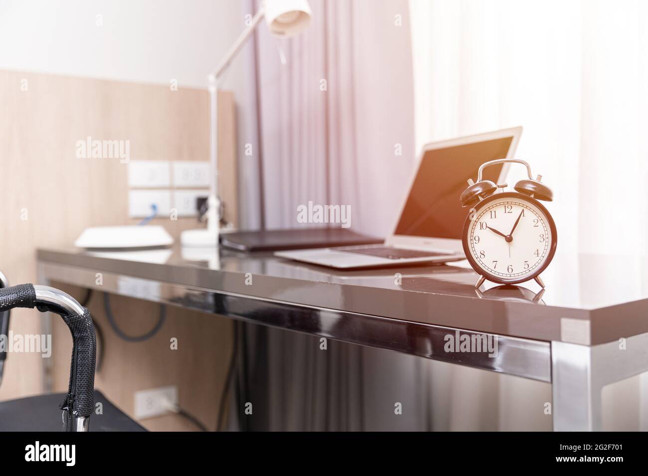 Arbeitsbereich zu Hause oder Schreibtisch mit Wecker, morgens zu Hause Bürozeiten Arbeitszeitkonzept. Stockfoto