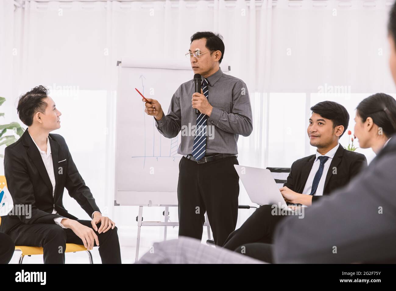 Asian Businessman Meeting oder Firmenkonferenz Verkauf Bericht Zieldiskussion. Professioneller Manager im Gespräch mit jungen neuen Mitarbeitern für die Geschäftsplanung ein Stockfoto