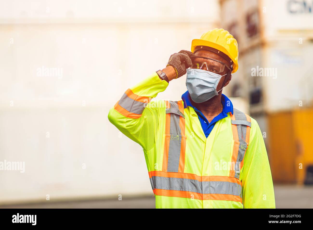 Arbeiter tragen Einweg-Gesichtsmaske zum Schutz Corona Virus Verteilung und Rauchstaub Luftverschmutzung Filter in Frachthafen Schifffahrt Industrie. Stockfoto
