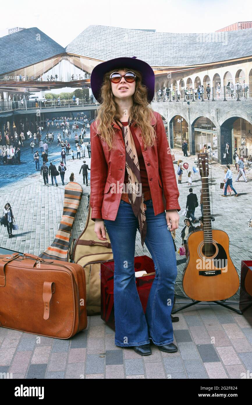 Ein Mädchen in der Kleidung im Vintage-Stil der 70er Jahre posiert beim klassischen Autoboot-Verkauf Stockfoto