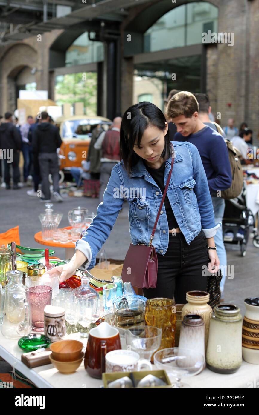 Junge asiatische Frau, die auf dem Flohmarkt einkauft Stockfoto
