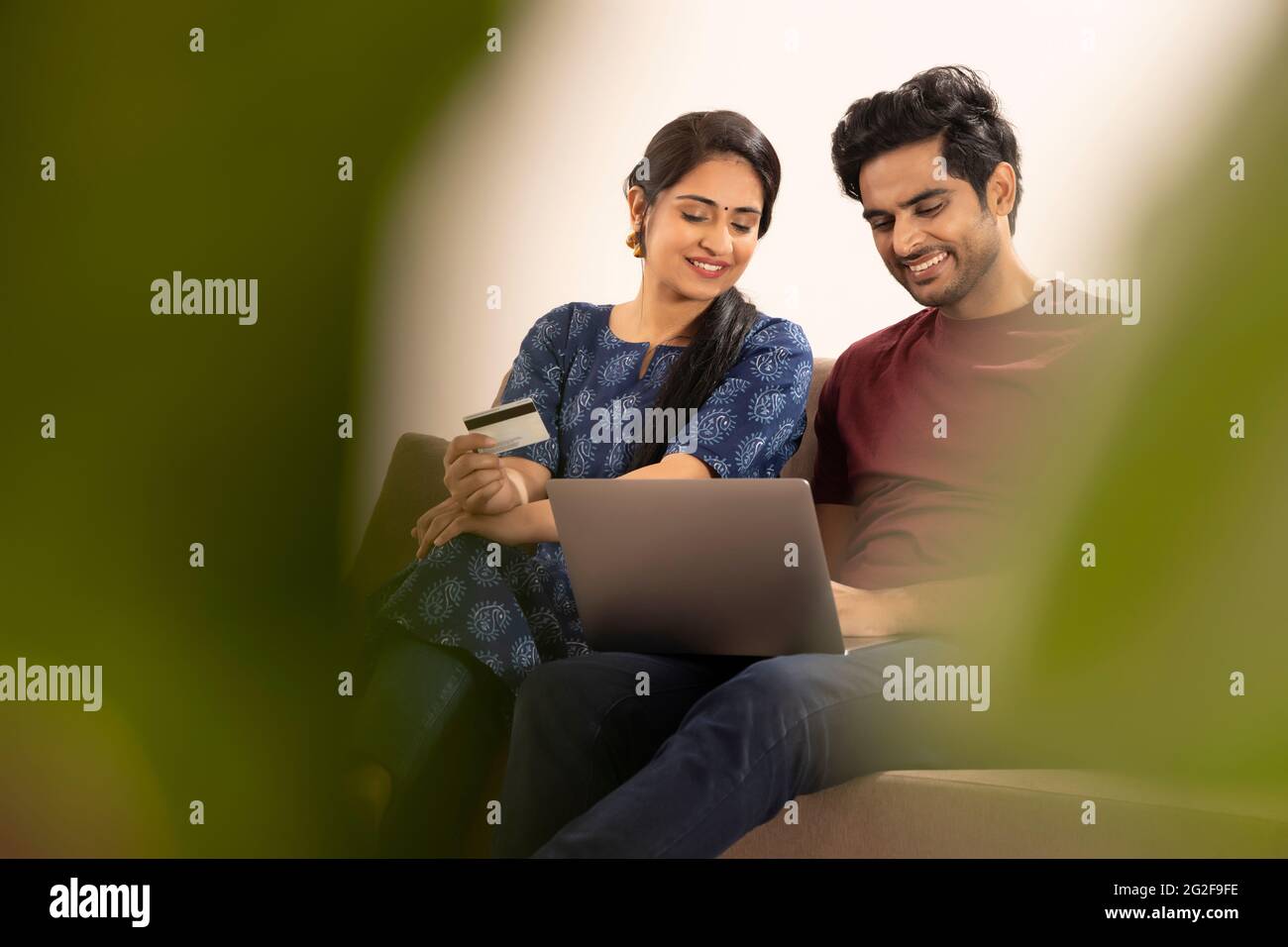 EIN MANN UND EINE FRAU SITZEN ZUSAMMEN UND MACHEN ONLINE-TRANSAKTIONEN Stockfoto