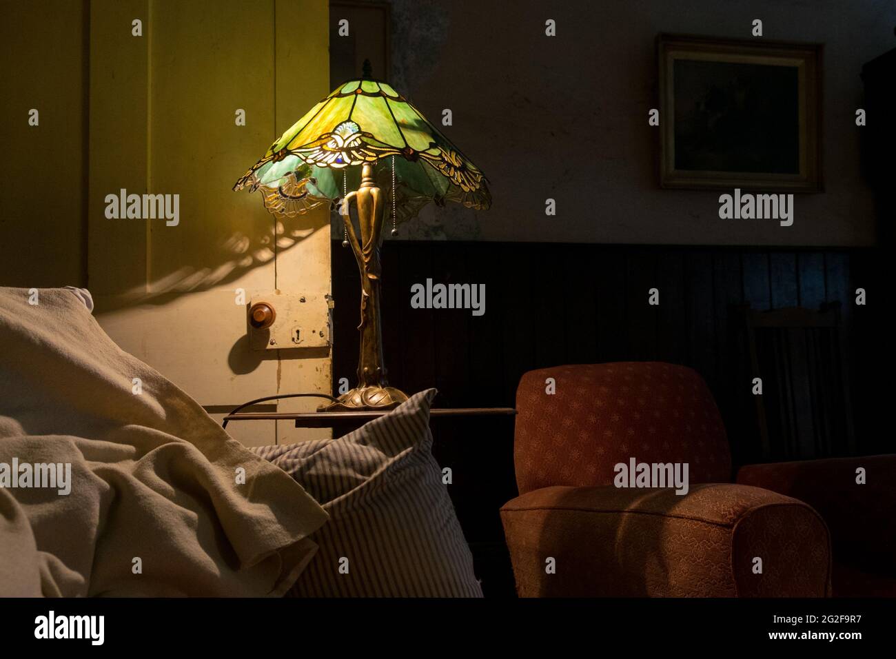 Eine Jugendstil-Lampe mit Tiffany-Lampenschirm aus Buntglas, der wunderschöne Schatten erzeugt. --- EIN Wochenende im Brooklyn House, Martham Stockfoto