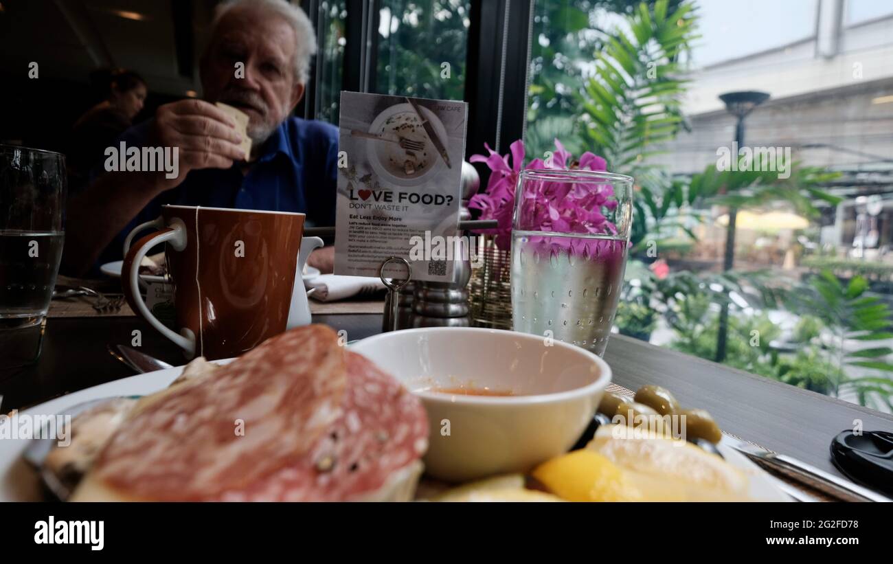 Objektivkappe im Rahmen Fotograf Fehler Wasserglas zur Mittagszeit Essen aus fünf-Sterne-Gelegenheitsessen Person im Hintergrund Stockfoto