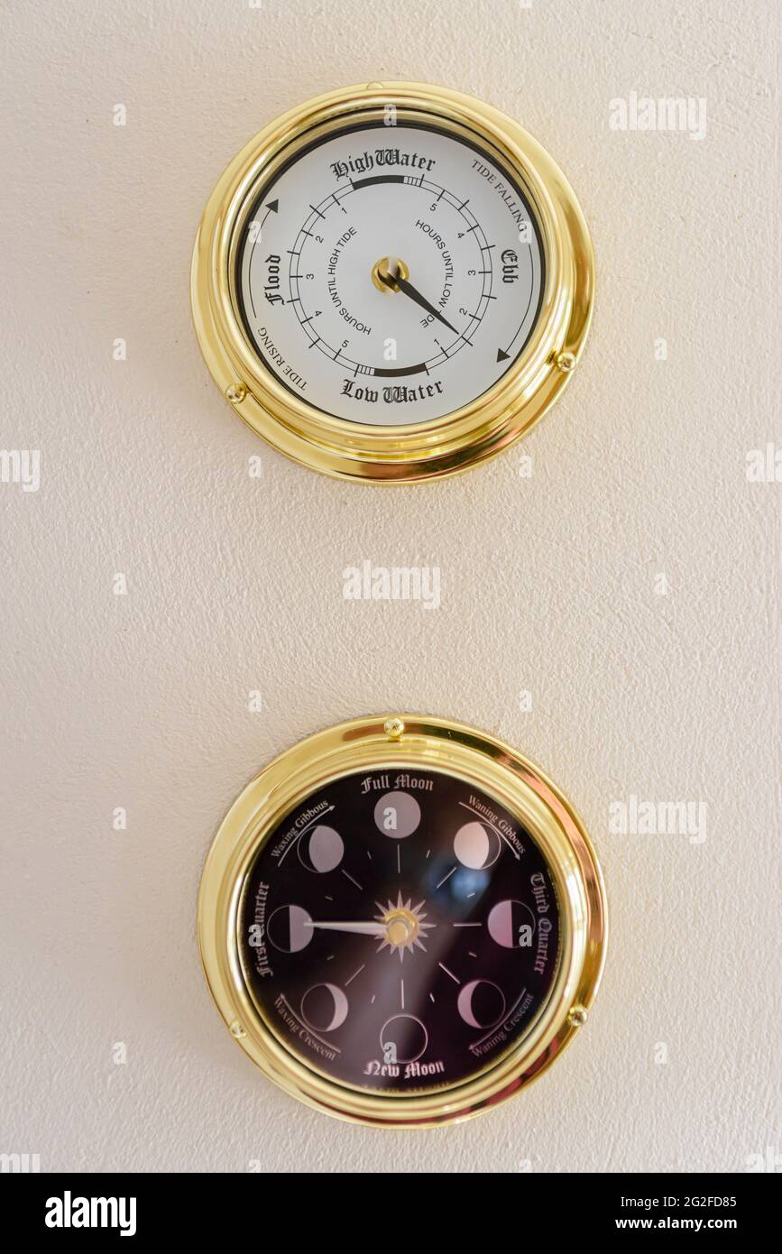 Messinguhr und Mondphasenuhr an einer Wand Stockfoto