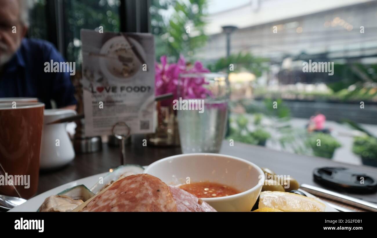 Objektivkappe im Rahmen Fotograf Fehler Wasserglas zur Mittagszeit Essen aus fünf-Sterne-Gelegenheitsessen Person im Hintergrund Stockfoto