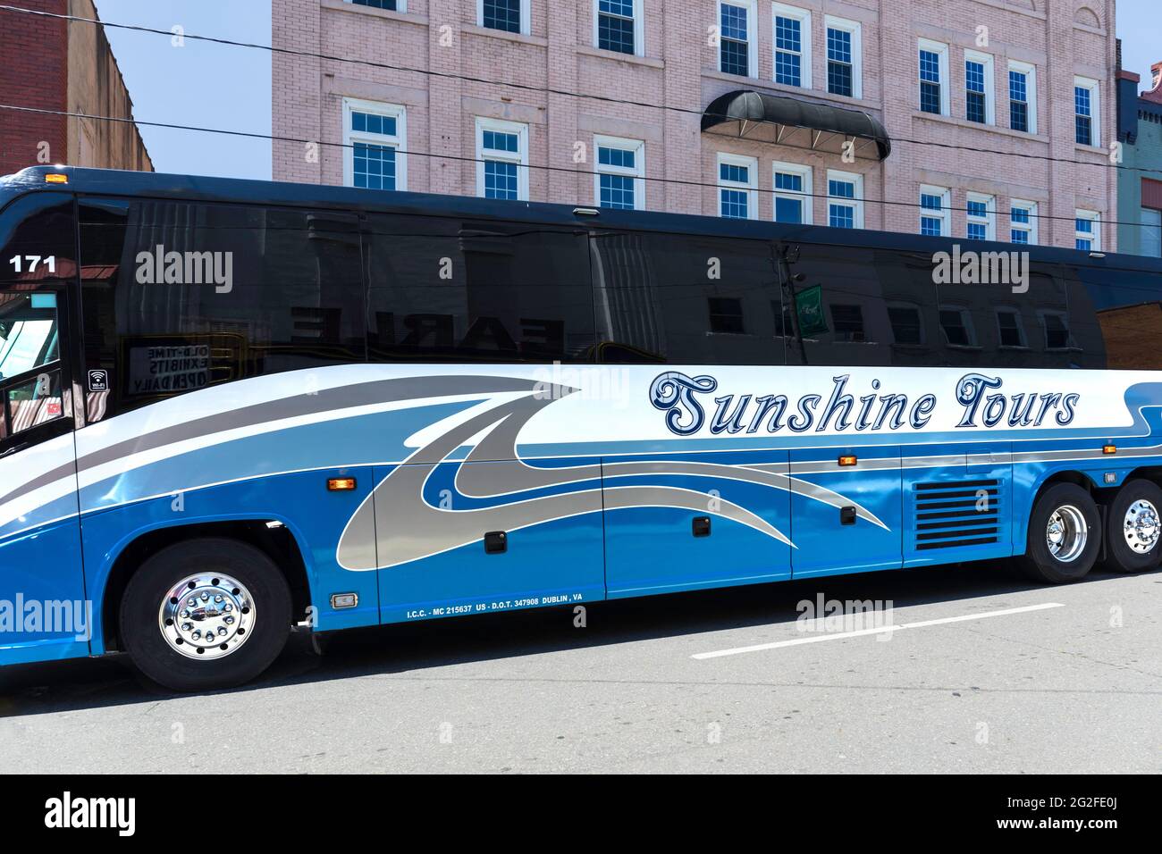 MT. AIRY, NC, USA-5 JUNE 2021: Ein blau glänzender Sunshine Tours Bus fährt die Main Street entlang. Stockfoto