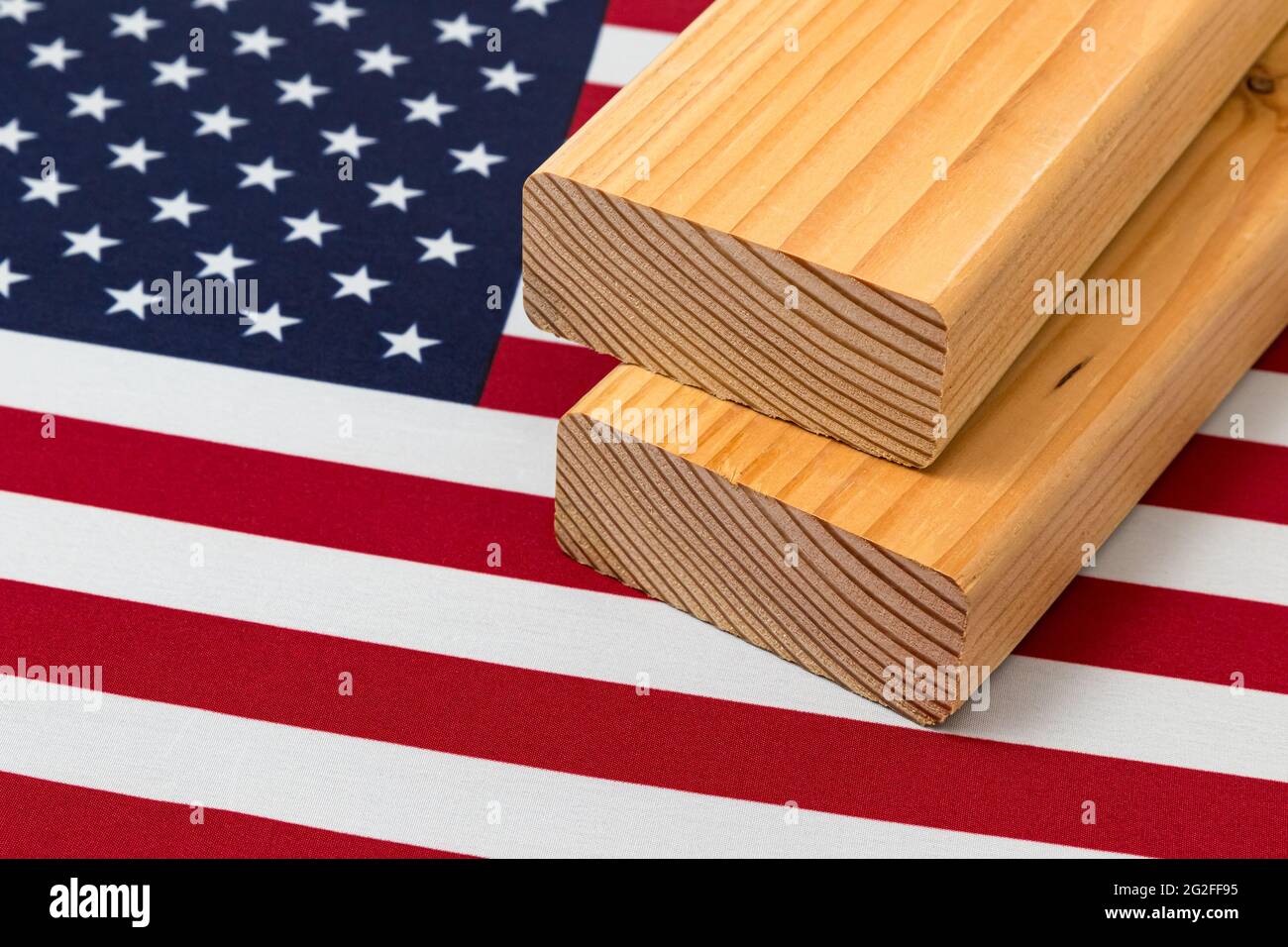 Weichholz Bauholz auf der Flagge der Vereinigten Staaten von Amerika. Konzept von Handelskrieg, Zöllen, fairem Handel und Holz, Holzwirtschaft Stockfoto