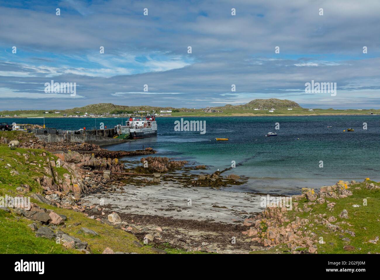 Eine kaledonische MacBrayne-Fähre am Fährhafen Fionnphort auf der Isle of Mull, Inner Hebrides, Schottland. Die Insel Iona in der Ferne. Stockfoto