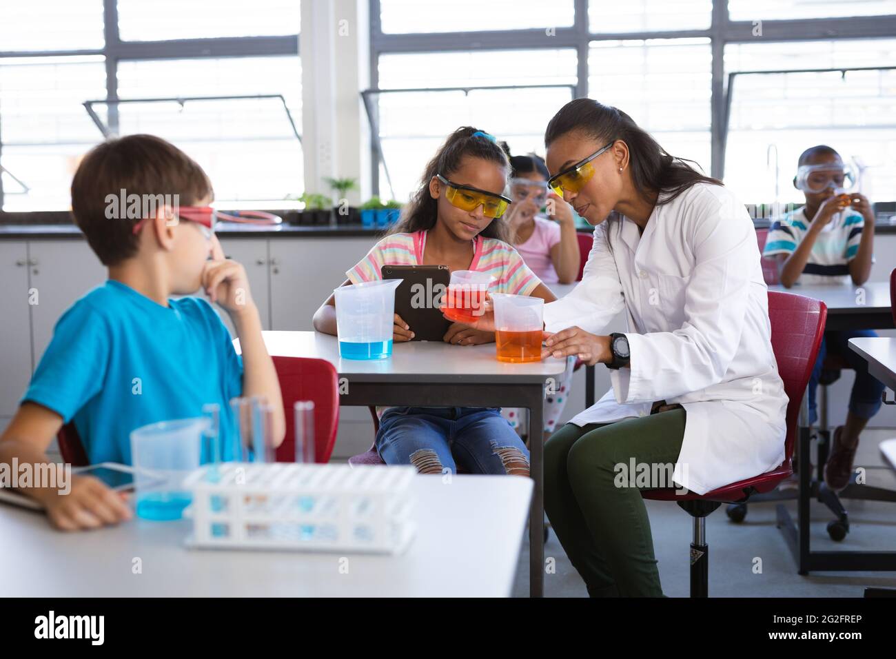 afroamerikanische Lehrerin, die einem Mädchen während des wissenschaftlichen Unterrichts im Labor Chemie lehrt Stockfoto