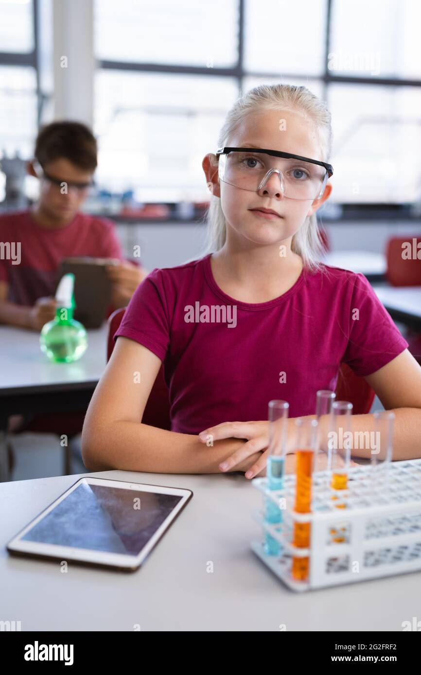Porträt eines kaukasischen Mädchens mit Schutzbrille in der wissenschaftlichen Klasse im Labor Stockfoto