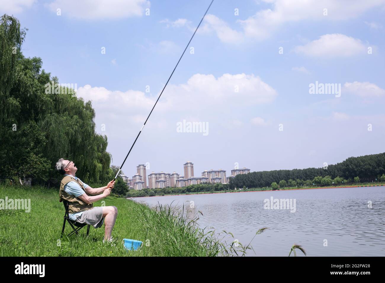 Ein alter Mann fischte am See auf einem qualitativ hochwertigen Foto Stockfoto