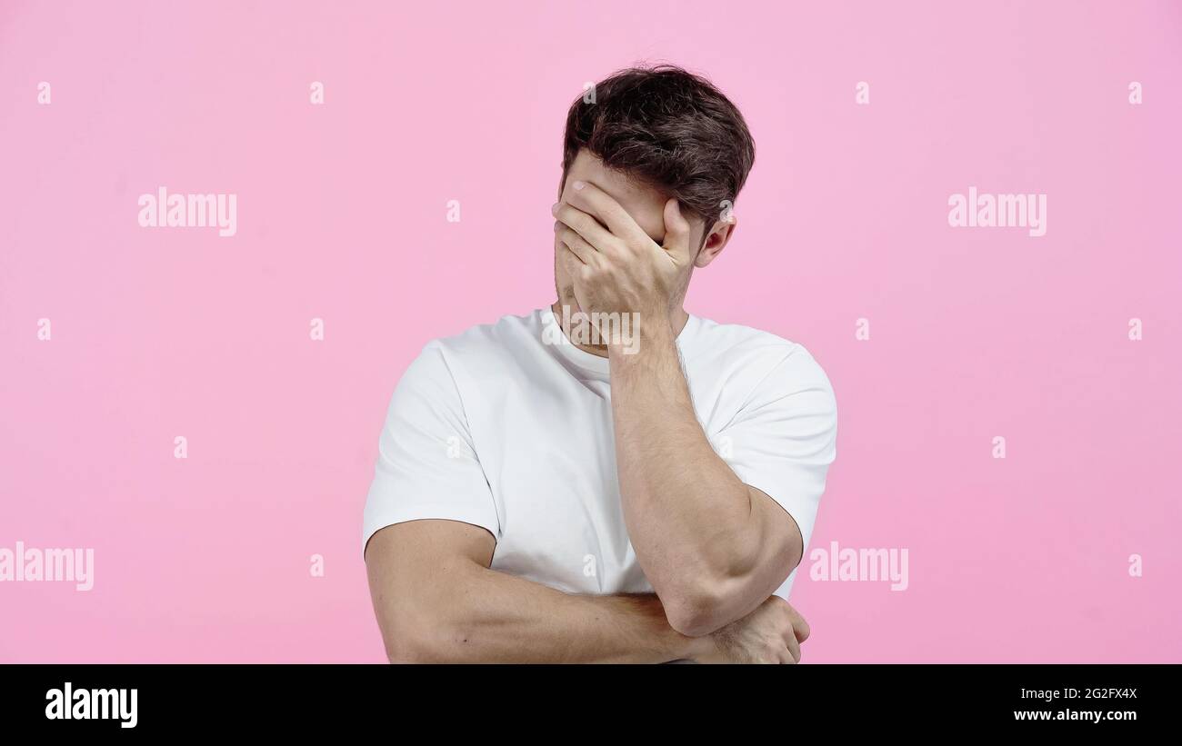 Mann in weißem T-Shirt mit Gesicht isoliert auf rosa Stockfoto