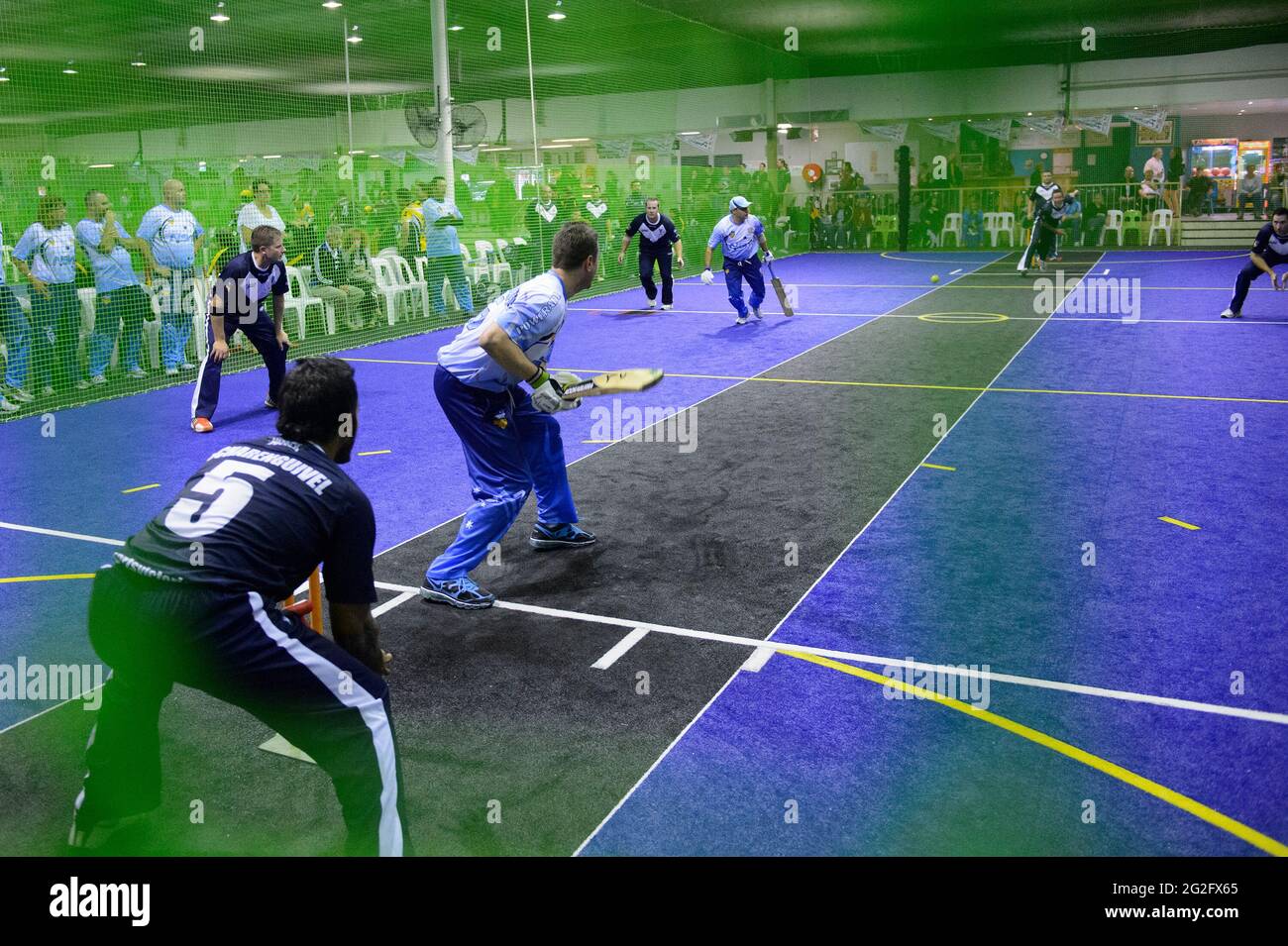 Batsman bereitet sich darauf vor, einen Schuss zu spielen, während ihm der Ball in einem Spiel von Indoor Cricket zugeschlagen wird Stockfoto