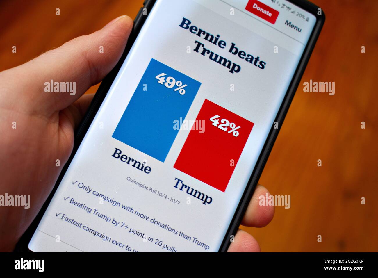 Hand hält ein Telefon und zeigt mögliche Wahlergebnisse an Stockfoto