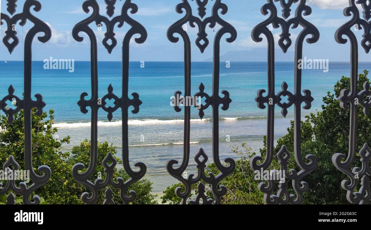 Lebt auf den Seychellen, Mahe. Meerblick durch die Balkongeländer Stockfoto