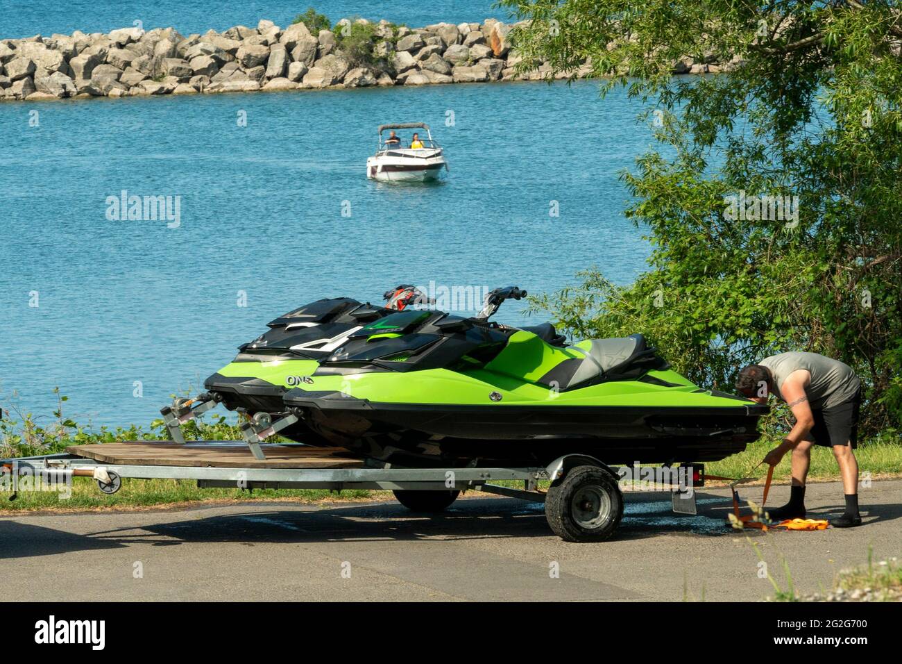 Man lädt zwei Jetskis auf einen Anhänger Stockfoto