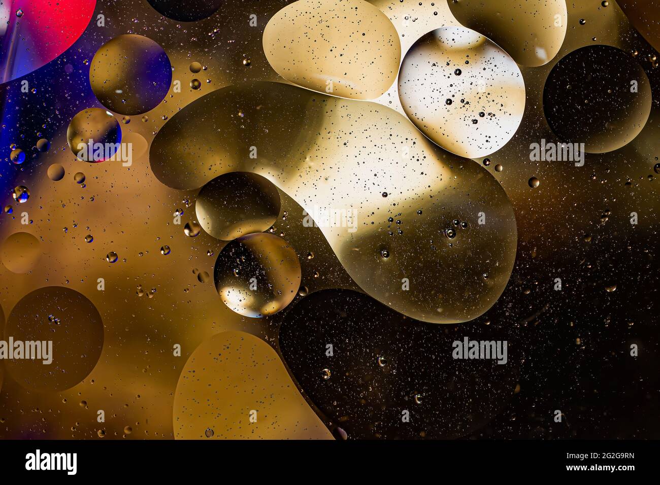 Foto von Öl auf einer Wasseroberfläche mit Blasen. Abstrakter, farbenfroher Hintergrund. Makro-Nahaufnahme, nicht Illustration . Stockfoto