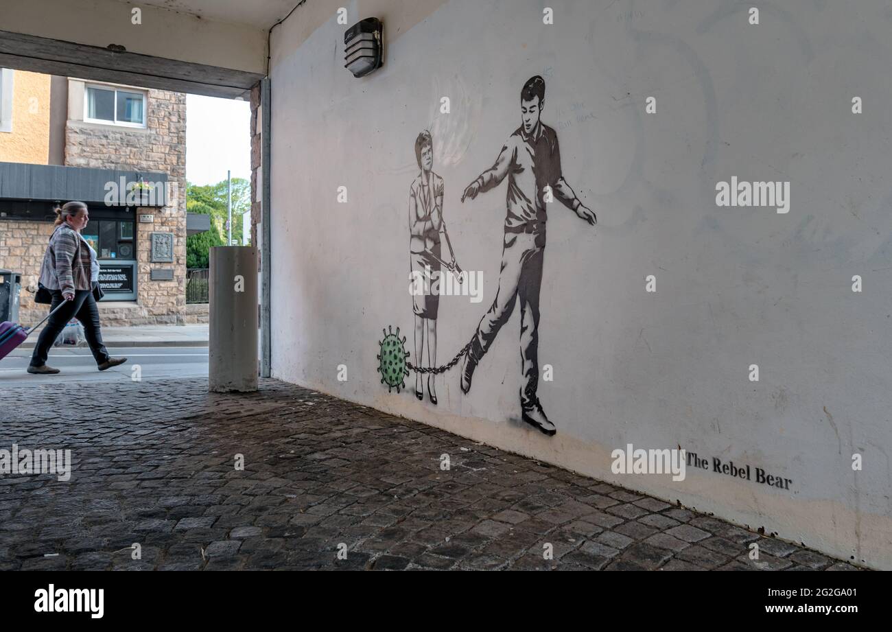 Rebel Bear Graffiti an der Gassenwand mit einer konzeptuellen Darstellung von Covid-19 Coronavirus, einem Mann mit Kugel und Kette & Nicola Sturgeon mit Schraubenschneidern, die das mögliche Ende der Sperrbeschränkungen während der Pandemie darstellen, Canongate, Edinburgh, Schottland, Großbritannien Stockfoto