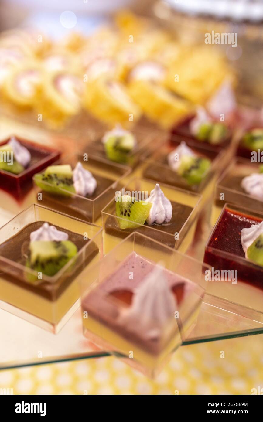 Süße Desserts in Plastikbechern auf einer Kinderparty. Stockfoto