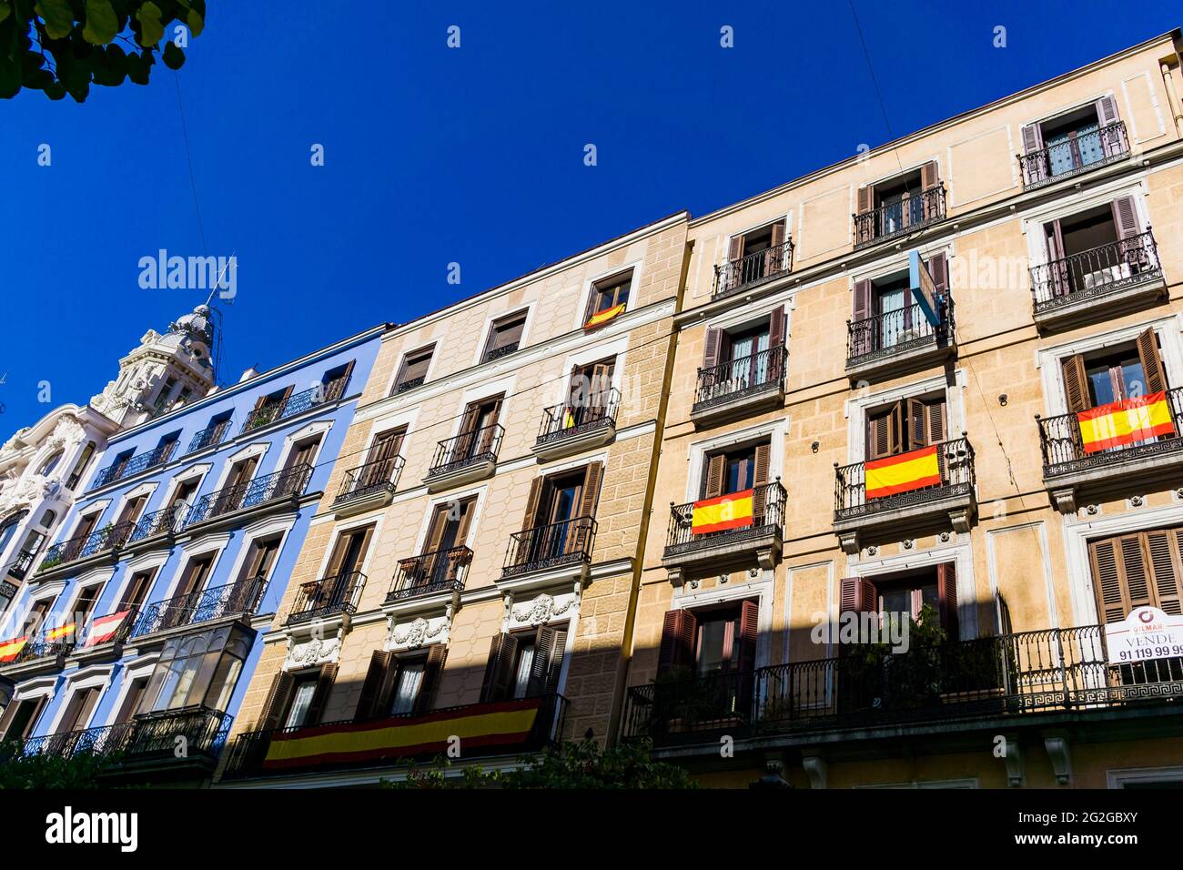 Teilweise Aussicht mit Balkonen, die mit spanischen Flaggen geschmückt sind. Die Calle Mayor, Hauptstraße, ist eine zentrale Straße in Madrid, Spanien. Das Hotel liegt im Centro Dis Stockfoto