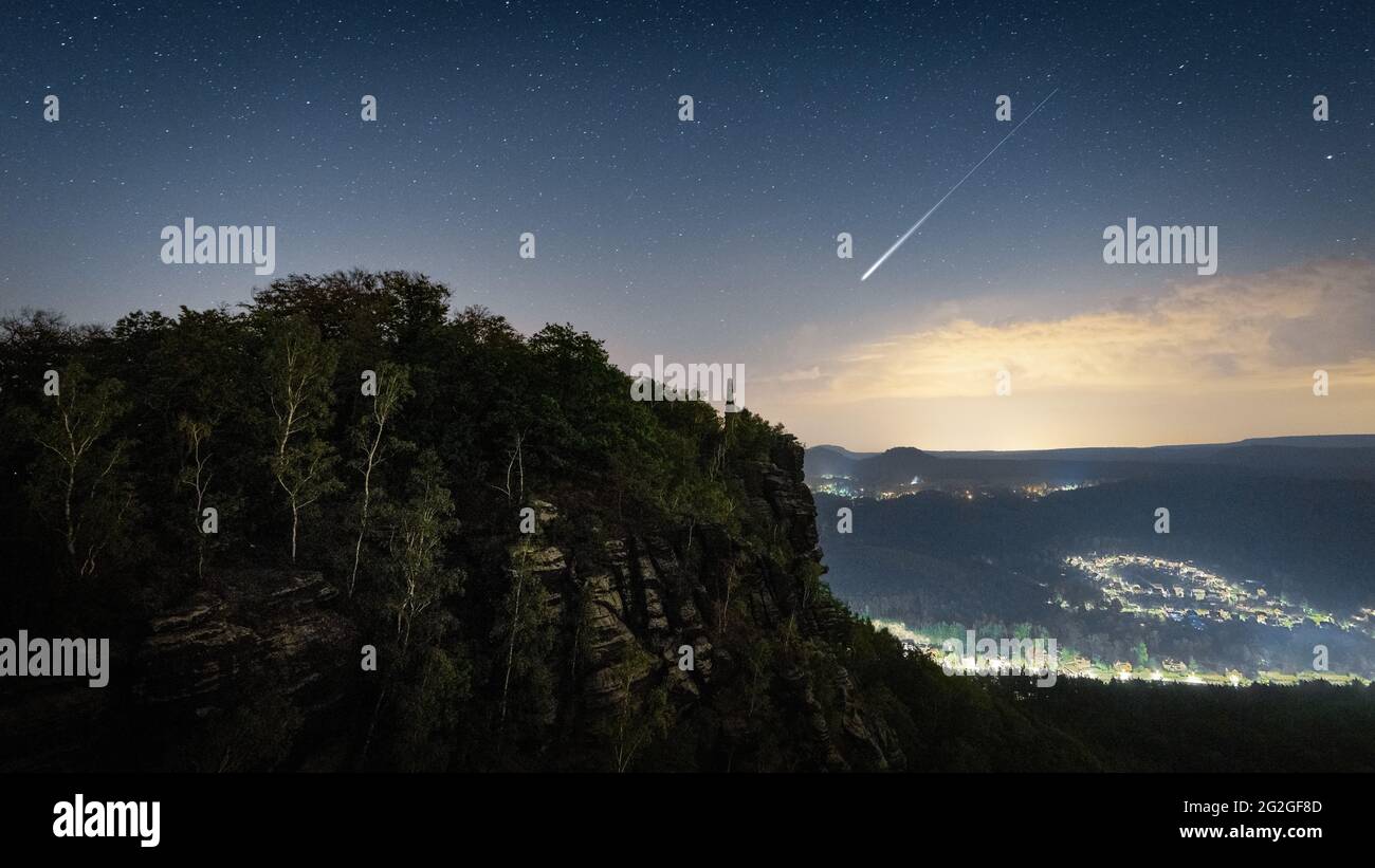 Nächtlicher Sternenhimmel mit Sternschnuppe der Perseiden über dem Elbsandsteingebirge. Stockfoto