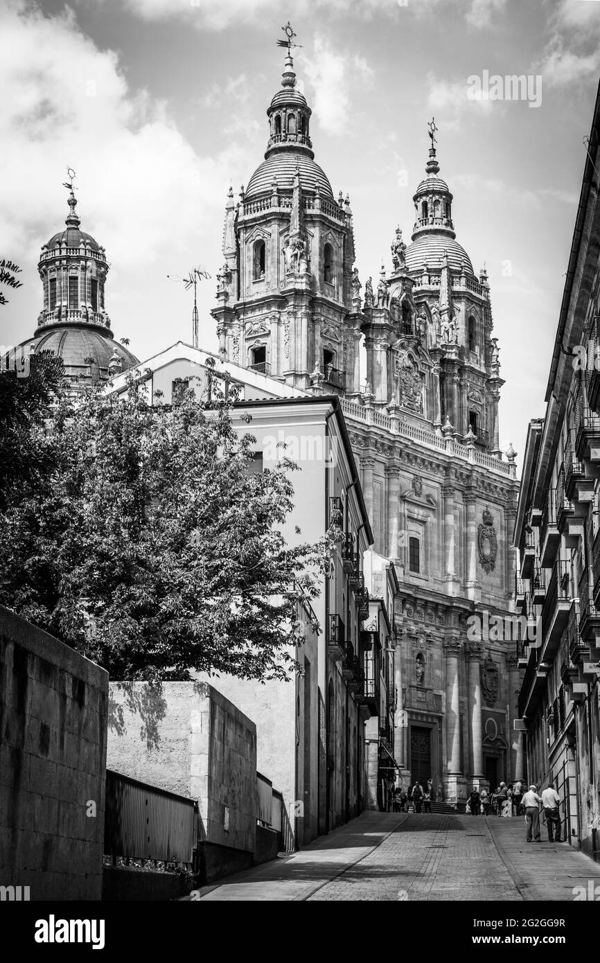 Straße in Salamanca mit der Kirche La Clerecia am Ende, Spanien. Schwarz-weißes Stadtbild Stockfoto