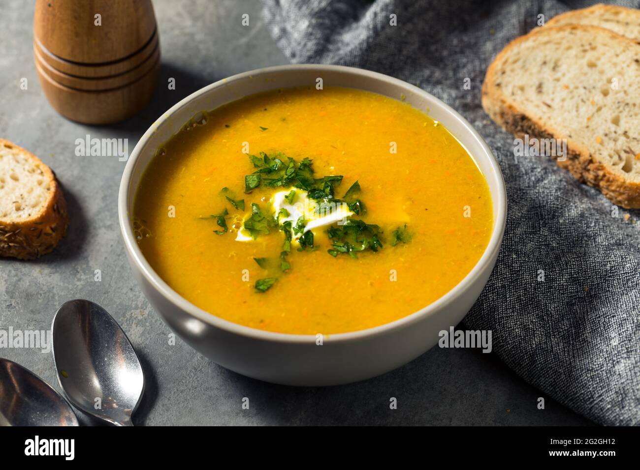 Hausgemachte gesunde Karotten-Lentil-Suppe mit Petersilie und Sour Cream Stockfoto