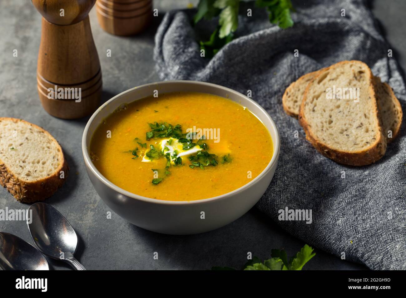 Hausgemachte gesunde Karotten-Lentil-Suppe mit Petersilie und Sour Cream Stockfoto