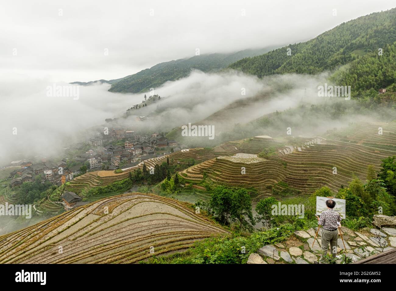 Ein Künstler malte die erhöhte Landschaft der Reisfelder an einem nebligen Tag auf Longsheng Reisterrassen, Longji, China Stockfoto