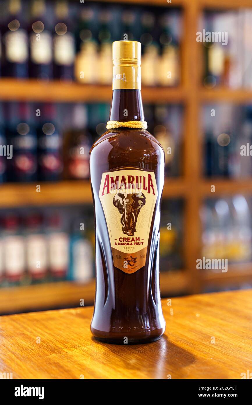 Amarula-Likörflasche auf einer Holzbar mit einem nicht fokussierten Pub-Hintergrund. Stockfoto