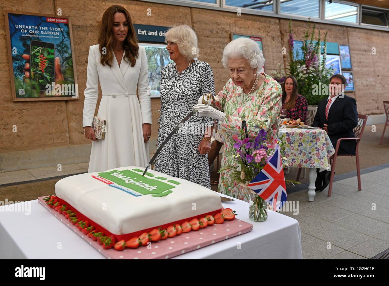 Königin Elizabeth II., die Herzogin von Cornwall und die Herzogin von Cambridge, schnitten einen Kuchen, als sie während des G7-Gipfels in Cornwall an einer Veranstaltung im Eden Project zur Feier der Big Lunch-Initiative teilnahmen. Bilddatum: Freitag, 11. Juni 2021. Stockfoto