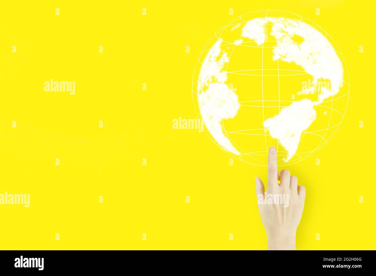 Medien weltweit Technologiekonzept. Der Handfinger der jungen Frau zeigt mit einem Hologramm auf gelbem Hintergrund. Internationales Geschäftskonzept Stockfoto