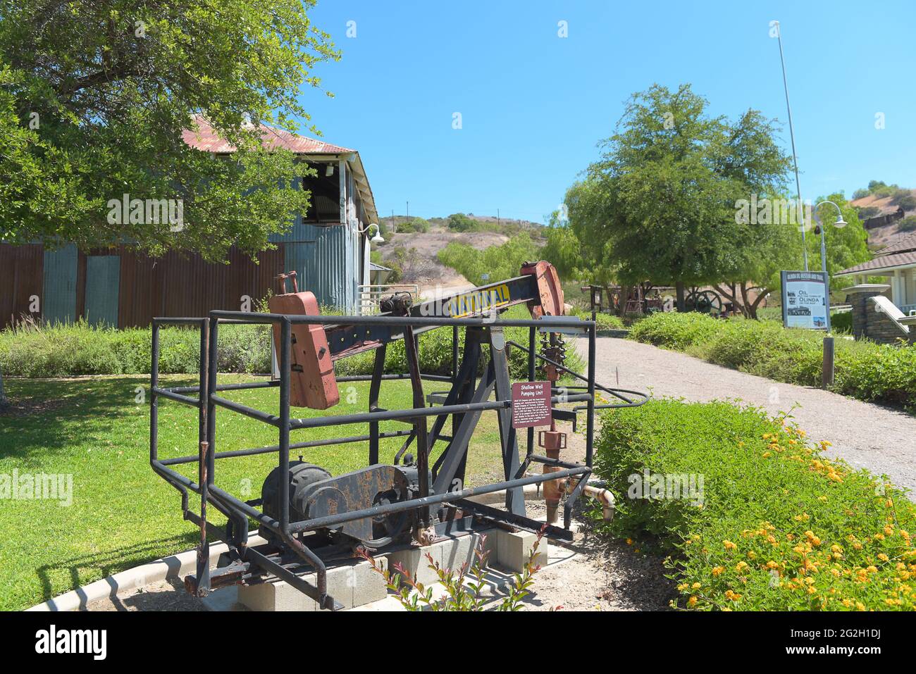 BREA, KALIFORNIEN - 9. JUNI 2021: Flacher Brunnenförderer im Olinda Oil Museum, mit dem Jack Line Pumpenhaus. Stockfoto