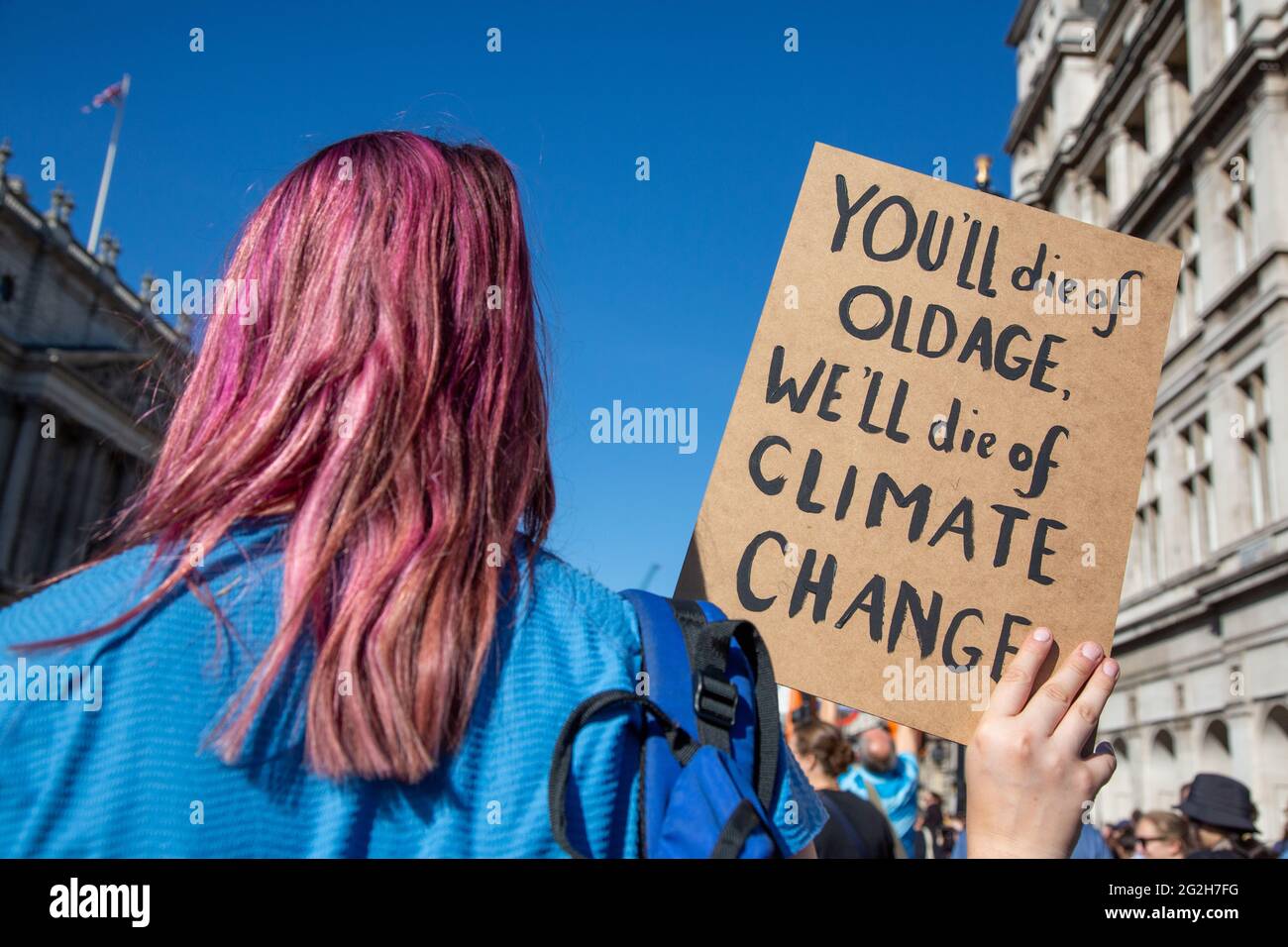 Ein Klimaproteste mit purpurfarbenen Haaren hält ein Schild auf der iat the Climate Change Protest auf dem Parliament Square, London, Großbritannien. 20.September 2019 Stockfoto