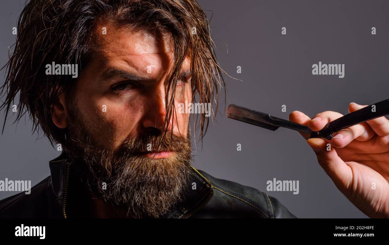 Professionelle Bartpflege. Schöner bärtiger Mann mit Rasiermesser. Barbershop. Stockfoto