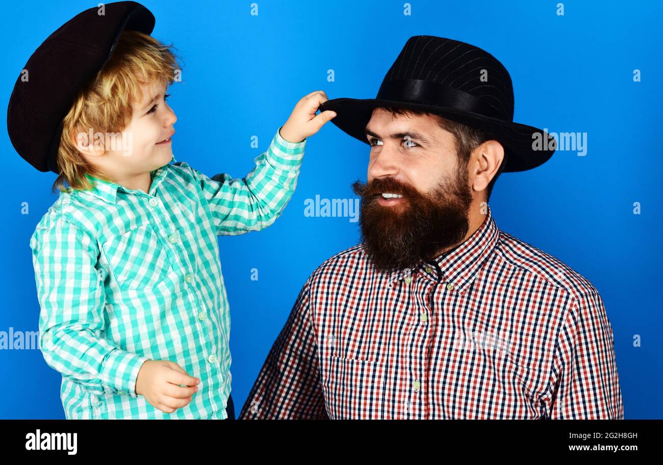 Vatertag. Fröhlicher Vater mit Sohn in karierten Hemden und modischen Hüten. Elternschaftskonzept Stockfoto