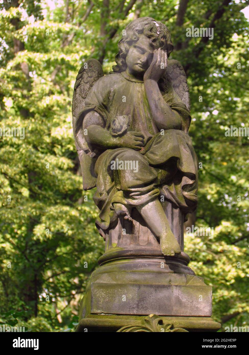 Alter Grabstein mit kindlicher Engelskulptur auf einem verlassenen Friedhof, Olsany Friedhof in Prag Stockfoto