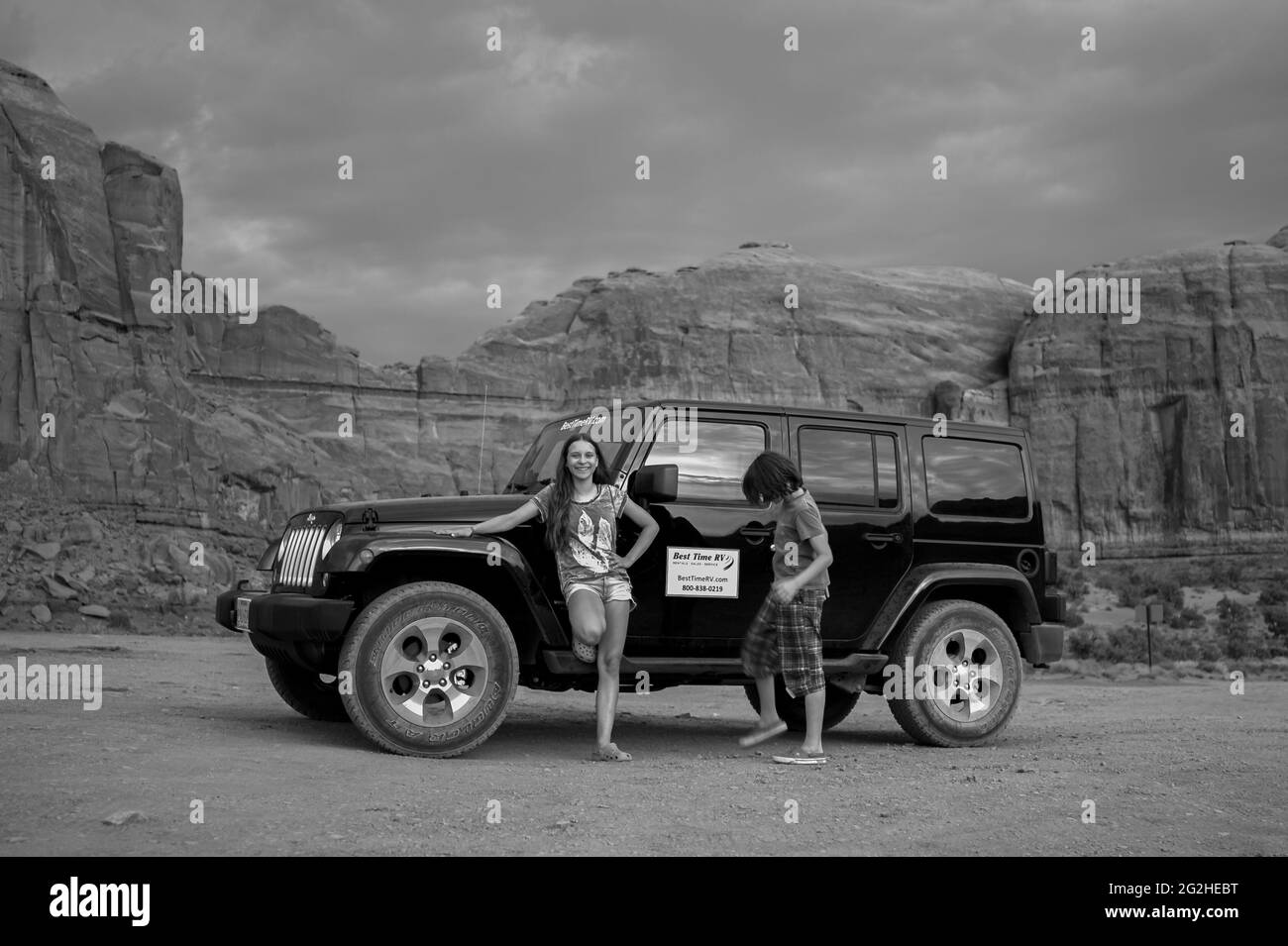Ein Mädchen und ein Junge vor einem Jeep Wrangler und eine klassische Ansicht des Monument Valley von Artist Point aus. Monument Valley Navajo Tribal Park, Utah und Arizona, USA, Stockfoto