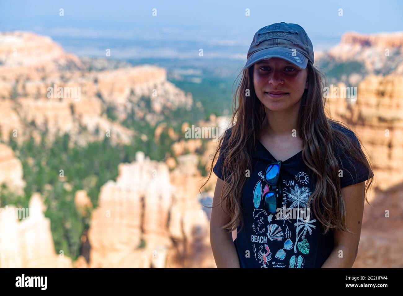 Ein Mädchen, 15-20 Jahre, kaukasisch, dunkelblond, das vor vielen Hoodoos am Sunset Point im Bryce Canyon National Park, Utah, USA, steht Stockfoto