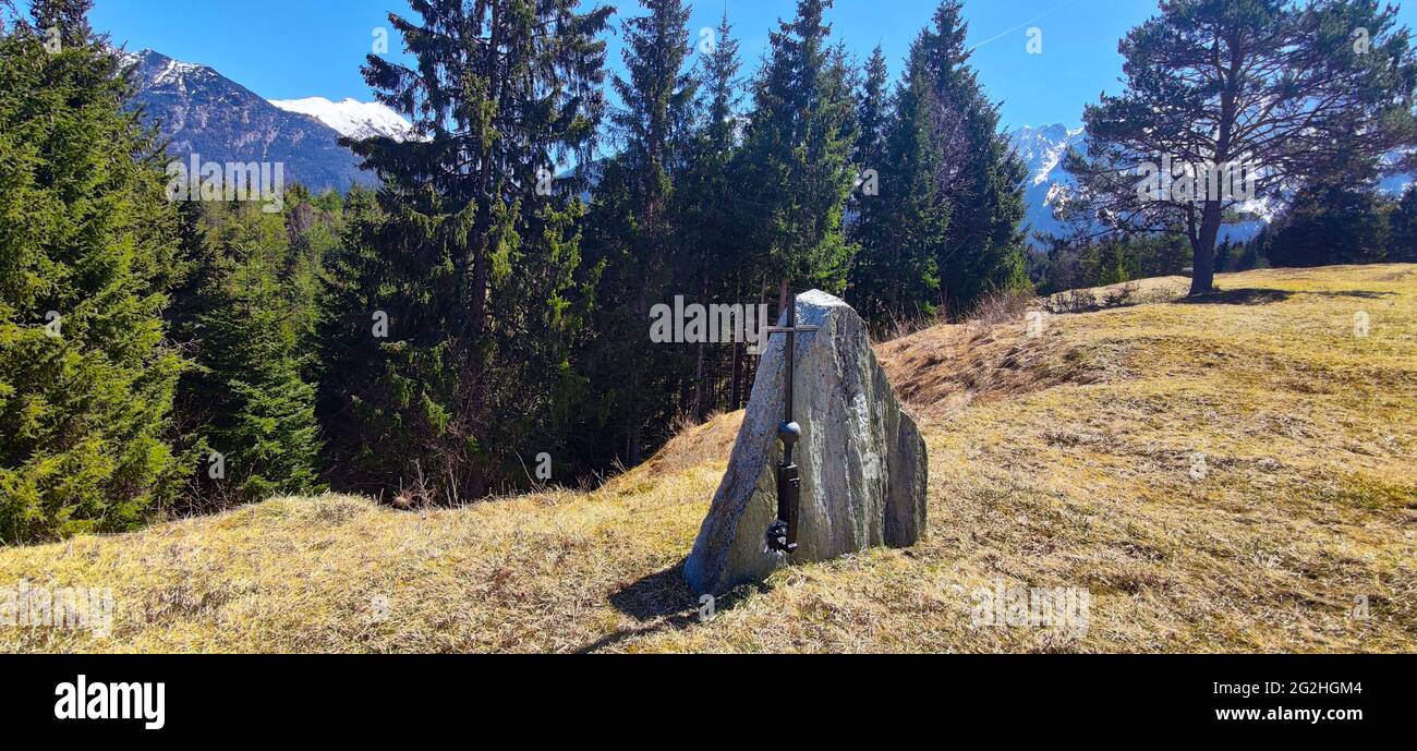 Der Gedenkstein steht ohne Schriftzug mit einem einfachen Metallkreuz am Waldrand. Ursache und Grund sind nicht bekannt Stockfoto