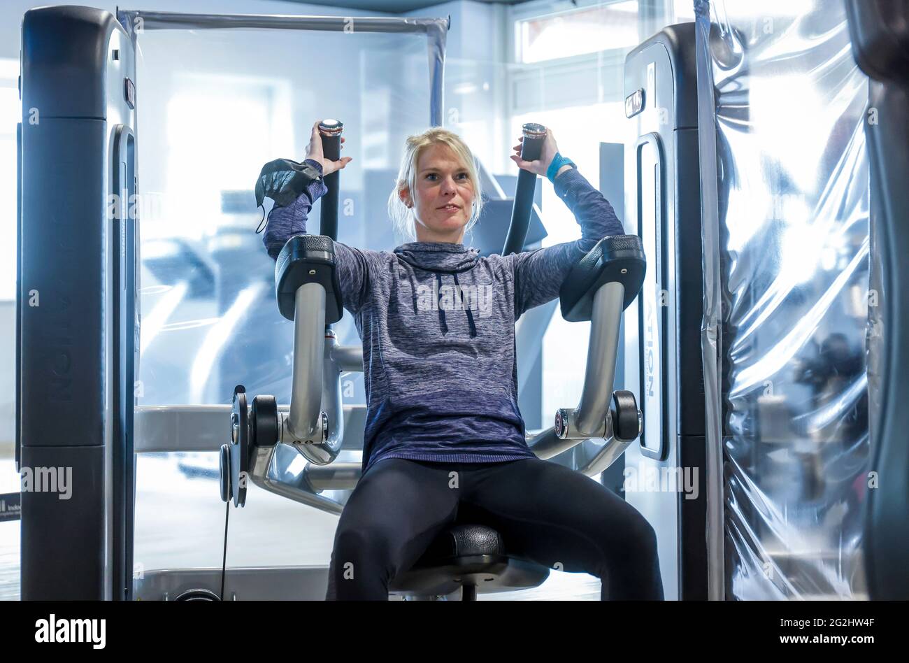 Coesfeld, Nordrhein-Westfalen, Deutschland - Fitnesstraining in Zeiten der Coronapandemie beginnt der Landkreis Coesfeld als Modellregion in Nordrhein-Westfalen mit Lockerung, in Havixbeck wird der Sportverein, ein Fitness- und Rehabilitationszentrum, eröffnet, Maximal 35 Mitglieder dürfen gleichzeitig Personalausweise und Luca-App nutzen Registrieren Sie sich für Kurse, ein aktueller negativer Corona-Test ist erforderlich, die Maske kann während des Trainings entfernt werden. - Modell freigegeben - Stockfoto