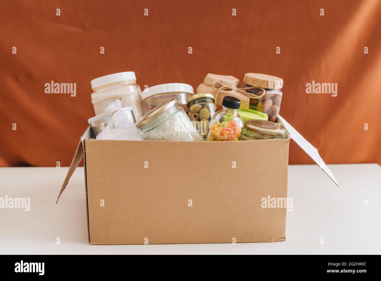 Pappkarton mit Lebensmitteln, Lebensmittelspende, Hauszustellung, horizontal, Kopierraum. Stockfoto