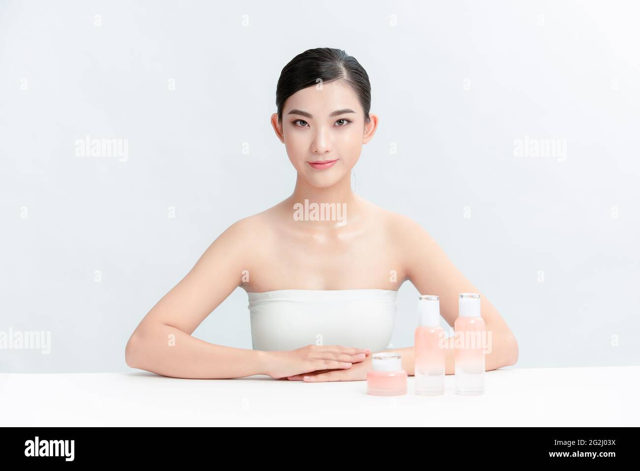 Fröhliche weibliche Vloggerin zeigt Kosmetikprodukte und gibt Ratschläge für ihren Beauty-Blog. Stockfoto