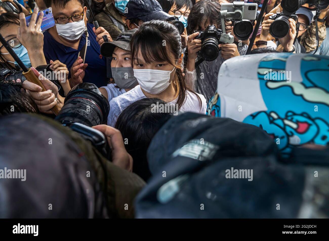 Hongkong, China. Juni 2021. Agnes Chow (C) geht durch das Medienpaket, nachdem sie aus der Tai Lam Correctional Institution entlassen wurde.die prodemokratische Aktivistin Agnes Chow wurde aus dem Gefängnis entlassen, nachdem sie fast sieben Monate lang wegen ihrer Rolle in einer nicht autorisierten Versammlung während der regierungsfeindlichen Proteste der Stadt im Jahr 2019 gedient hatte. Kredit: SOPA Images Limited/Alamy Live Nachrichten Stockfoto